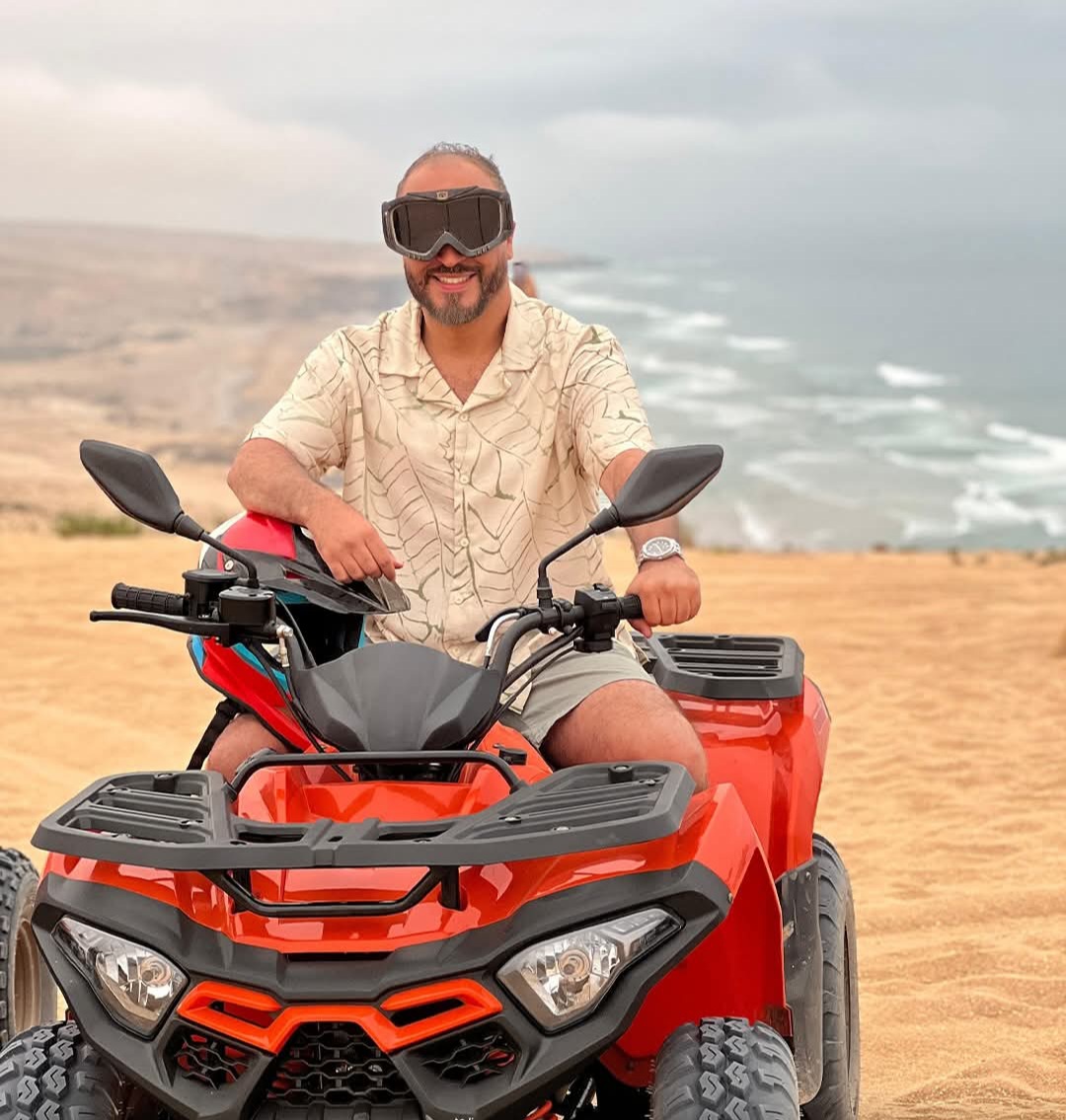 A man wearing goggles is sitting on a red quad timaline.